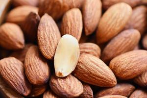 mandorle su sfondo vista dall'alto sul tavolo, primo piano mandorle tostate noci cibo proteico naturale e per spuntino foto