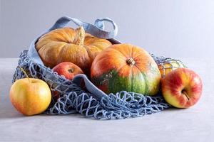 zucche e mele in un sacchetto a rete riutilizzabile ecologico foto
