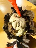 gelato alla vaniglia e al cioccolato con motivo di dessert congelato in tazza di cialda su legno. foto