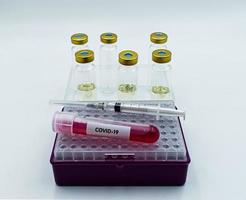 iniezione di siringa, campione di sangue infetto e campioni di vaccino covid 19. foto