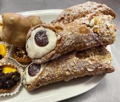 cannoli dolci siciliani, cannoli siciliani. dolce tipico del sud italia. dolci tipici siciliani. cannoli ripieni di crema di ricotta foto