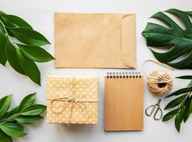 confezione regalo, busta e quaderno con foglie verdi foto