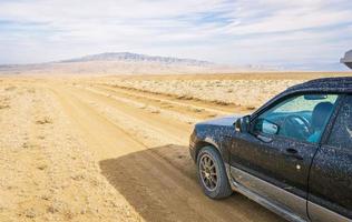 l'auto si trova sulla strada sterrata in un'area deserta nel parco nazionale di vashlovani. viaggio estremo nel caucaso foto