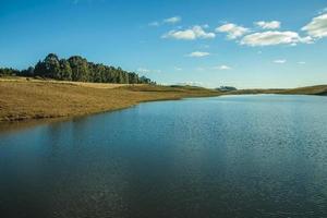 lago di acqua blu sul paesaggio delle pianure rurali chiamate pampa con cespugli secchi che coprono le colline vicino a cambara do sul. una piccola cittadina di campagna nel sud del Brasile con incredibili attrazioni turistiche naturali. foto