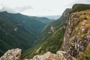 fortaleza canyon con ripide scogliere rocciose ricoperte da fitta foresta e nebbia che sale il burrone vicino a cambara do sul. una piccola cittadina di campagna nel sud del Brasile con incredibili attrazioni turistiche naturali. foto