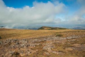 cima della scogliera più alta al canyon di fortaleza con paesaggio roccioso coperto da cespugli secchi e nuvole vicino a cambara do sul. una piccola cittadina di campagna nel sud del Brasile con incredibili attrazioni turistiche naturali. foto