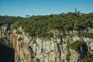 Itaimbezinho canyon con ripide scogliere rocciose che attraversa un altopiano pianeggiante coperto da foresta vicino a cambara do sul. una piccola cittadina di campagna nel sud del Brasile con incredibili attrazioni turistiche naturali. foto