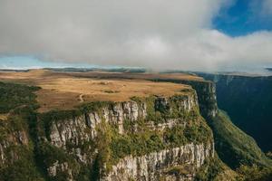 fortaleza canyon formato da ripide scogliere rocciose con foresta e altopiano pianeggiante coperto da cespugli secchi vicino a cambara do sul. una piccola cittadina di campagna nel sud del Brasile con incredibili attrazioni turistiche naturali. foto