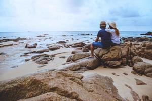 amanti asiatici felici sulla spiaggia.il cielo è brillante natura di viaggio e seduti rilassarsi sulle rocce al mare a phuket. in Thailandia. estate.
