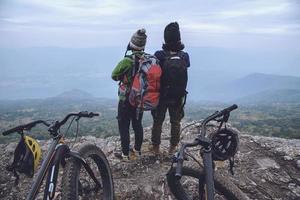 donne e uomini amante asiatici viaggiano nella natura. viaggio relax andare in bicicletta natura selvaggia. in piedi su una scogliera rocciosa. Tailandia foto