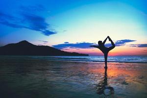 giovane donna yoga in spiaggia esercizio felice estate. foto