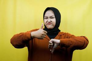 bella giovane donna musulmana asiatica con il segno della mano come o antipatia, sì o no, felice o triste, confrontando due cose, isolate foto