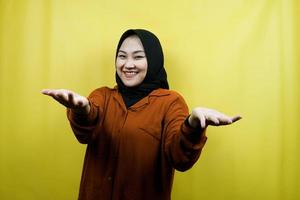 bella e allegra giovane donna musulmana asiatica, a braccia aperte, benvenuta, che presenta qualcosa di felice, isolata