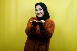 bella e allegra giovane donna musulmana asiatica, a braccia aperte, che presenta qualcosa di felicemente, isolata foto