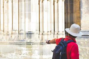 la persona guida maschile in rosso mostra elementi di monumenti storici nella città europea foto