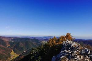 incredibile ampia vista dalla vetta di una montagna al paesaggio con altre colline con cielo blu foto