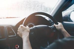 mano della donna sul volante guidare un'auto con sfondo di luce solare. foto