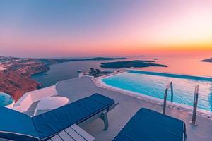 piscina a sfioro sul tetto al tramonto nell'isola di santorini, in grecia. bellissimo cielo a bordo piscina e al tramonto. lussuose vacanze estive e concetto di vacanza, paesaggi romantici e vista serale