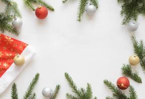 cappello da Babbo Natale con palline d'oro, due palline rosse e quattro palline d'argento e rami di albero di natale. foto