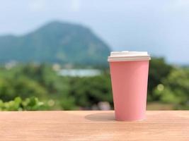 la tazza di caffè di cartone sta nell'aria fresca foto