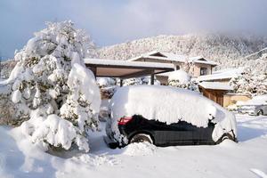 fresca neve bianca che cade al parco pubblico copre la strada e l'auto nella stagione invernale a kawaguchiko, in giappone foto