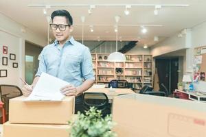 imprenditore asiatico che controlla il documento a casa. concettuale per l'avvio di piccole imprese che iniziano la propria azienda e il marketing online. foto