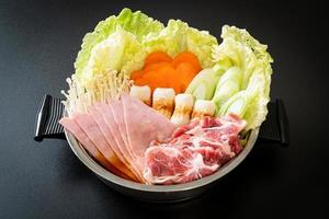 zuppa nera di sukiyaki o shabu con carne cruda e verdure foto