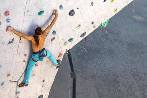 un uomo sta scalando una parete da arrampicata foto