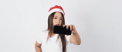 donna asiatica con smartphone in mano che posa come selfie o videochiamata