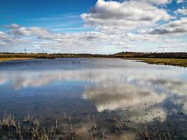 Le nuvole si riflettono nelle zone umide a Fairburnings, West Yorkshire, Inghilterra foto