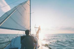 un uomo e una donna stanno viaggiando su uno yacht a vela. foto