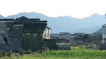 la bella e antica vista del villaggio tradizionale cinese con le montagne intorno situata nella campagna della Cina meridionale foto