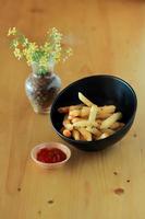 spuntino di patate fritte in una ciotola e la salsa in tavola foto