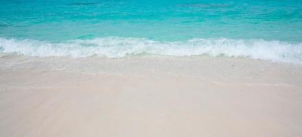 spiaggia con sabbia bianca e morbida onda blu dell'oceano foto