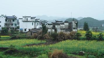 la bella e antica vista del villaggio tradizionale cinese con le montagne intorno situata nella campagna della Cina meridionale foto