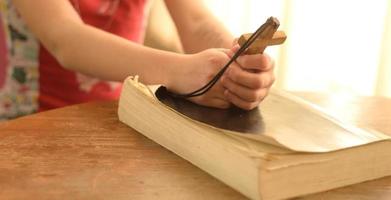 ragazza adolescente che prega Dio tenendo una croce di legno,concentrarsi sulla croce.concetto di fede,speranza e amore foto