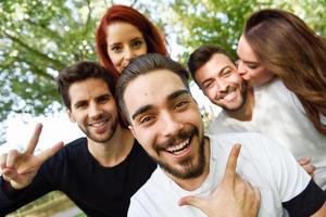 gruppo di amici che si fanno selfie sullo sfondo urbano foto