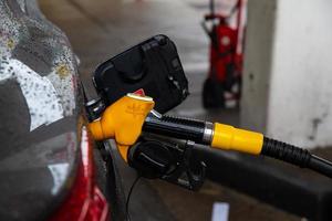 la pistola del carburante è installata nel serbatoio del veicolo, pistola del carburante gialla. foto