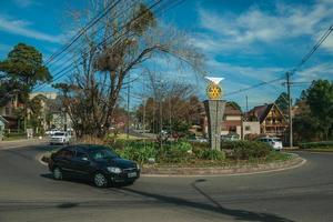 Gramado, Brasile - 21 luglio 2019. auto su rotatoria e giardino con logo internazionale rotante su piedistallo a gramado. una graziosa cittadina di influenza europea molto ricercata dai turisti. foto