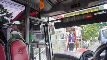 semarang, java centrale, indonesia, 2021 - i passeggeri entrano nel trasporto pubblico, il sistema di trasporto rapido degli autobus foto