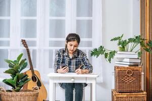 le donne si siedono alla scrivania e usano il telefono per coordinarsi. foto