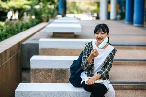 studentessa seduta sulle scale e leggere un libro. foto