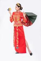 la donna indossa il vestito cheongsam sorride per usare la carta di credito per fare shopping nel capodanno cinese