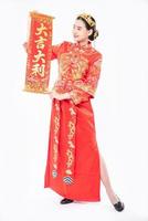 la donna indossa un abito cheongsam mostra alla famiglia il biglietto di auguri cinese per fortuna nel capodanno cinese