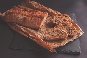 pane rustico, bella crosta dorata, fette di pane steso su tavola nera