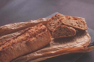 pane rustico, bella crosta dorata, fette di pane steso su tavola nera