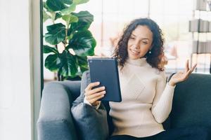 videoconferenza donna latina su tablet con sensazione felice foto