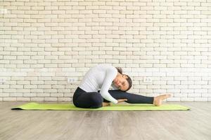 donna latina che pratica yoga su mat foto