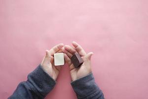 bambino che tiene cioccolato fondente e bianco su rosa foto