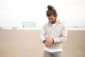 giovane con i capelli lunghi che indossa abbigliamento sportivo che corre all'aperto foto